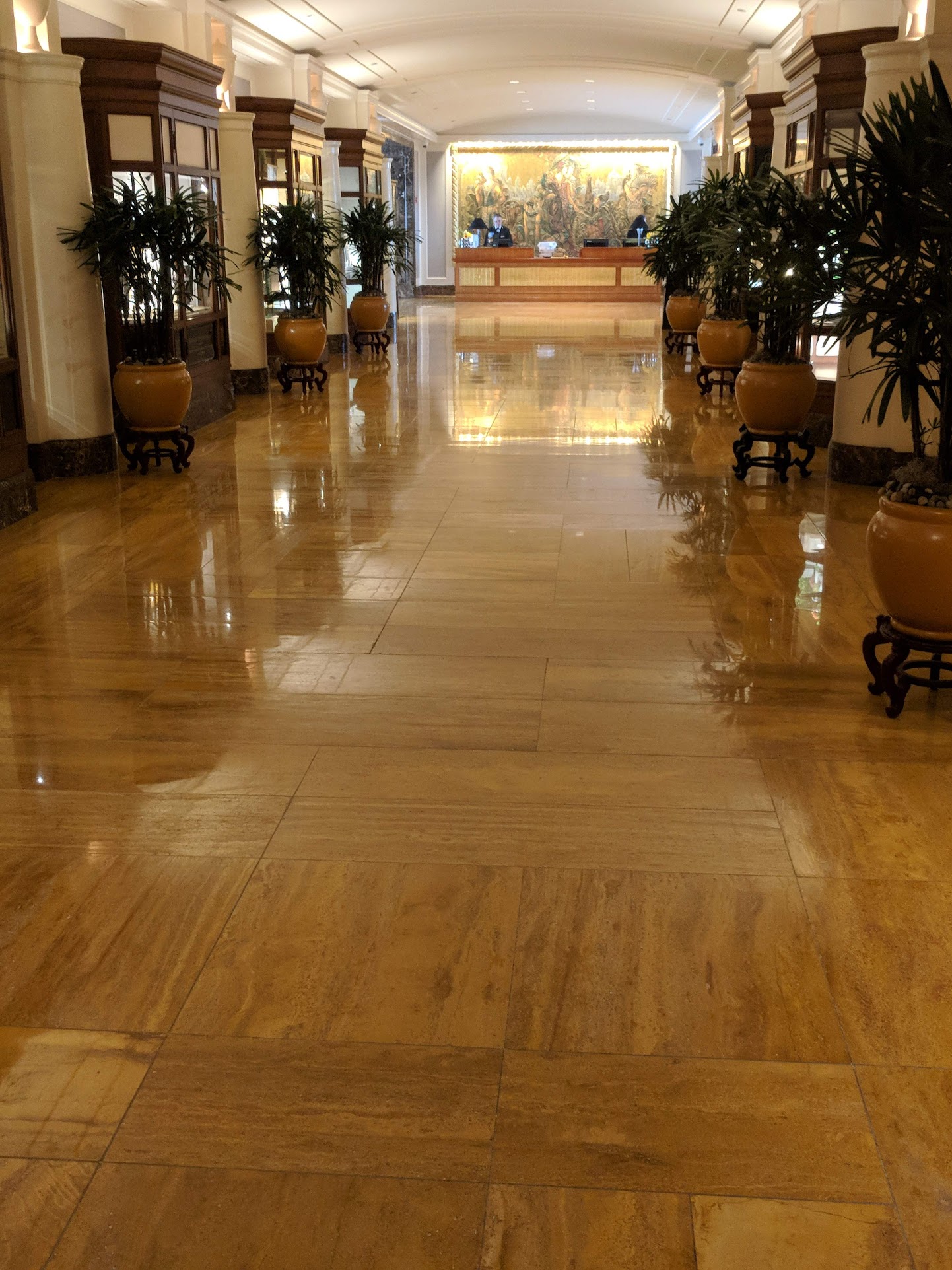 The Peninsula Hotel Chicago lobby floor reflecting front desk and display cabinets